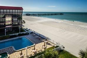 An elevated view of a beachfront swimming pool, a multi-story building, and a long pier — 17580 GULF BOULEVARD UNIT 206, REDINGTON SHORES, FL