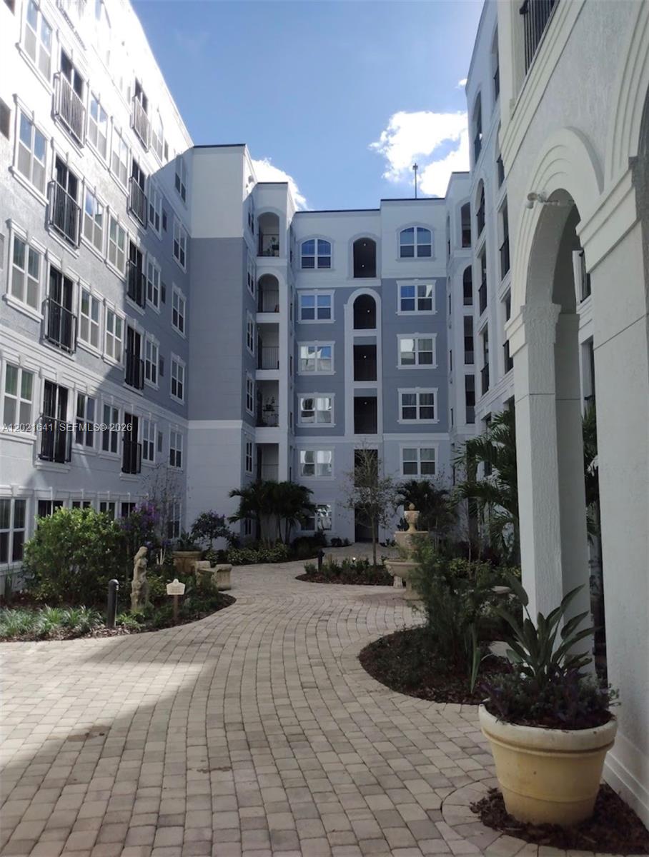 A paved courtyard with a fountain sits between the wings of a multi-story apartment building — 204 E South street # 1061, Orlando FL 32801, ORLANDO, FL