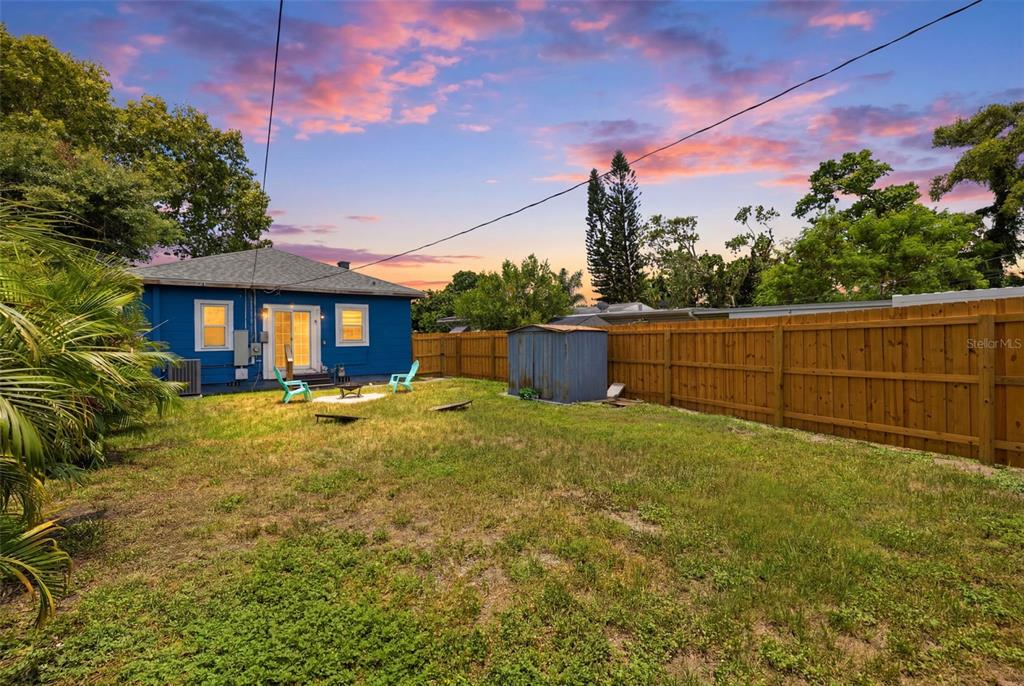 A blue house with a fenced backyard, a small shed, and two chairs on grass — 2237 14TH AVENUE N, ST PETERSBURG, FL