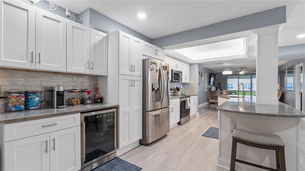 A modern kitchen features white cabinetry, stainless steel appliances, and a gray stone countertop — 4565 S ATLANTIC AVENUE UNIT 5110, PORT ORANGE, FL