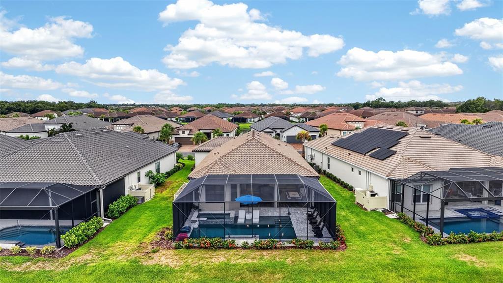 An aerial view of a suburban neighborhood featuring houses with screened-in pools and backyards — 5312 CASERTA COURT, PALMETTO, FL