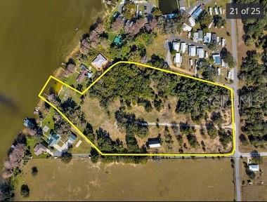 An aerial view shows a large, wooded waterfront property outlined in yellow — 25800 WASHINGTON STREET, ASTATULA, FL