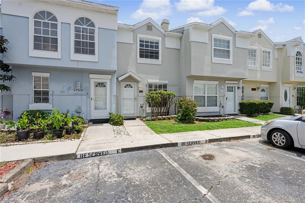 A row of multi-story townhomes with reserved parking spaces in front — 6721 121ST AVENUE UNIT D, LARGO, FL