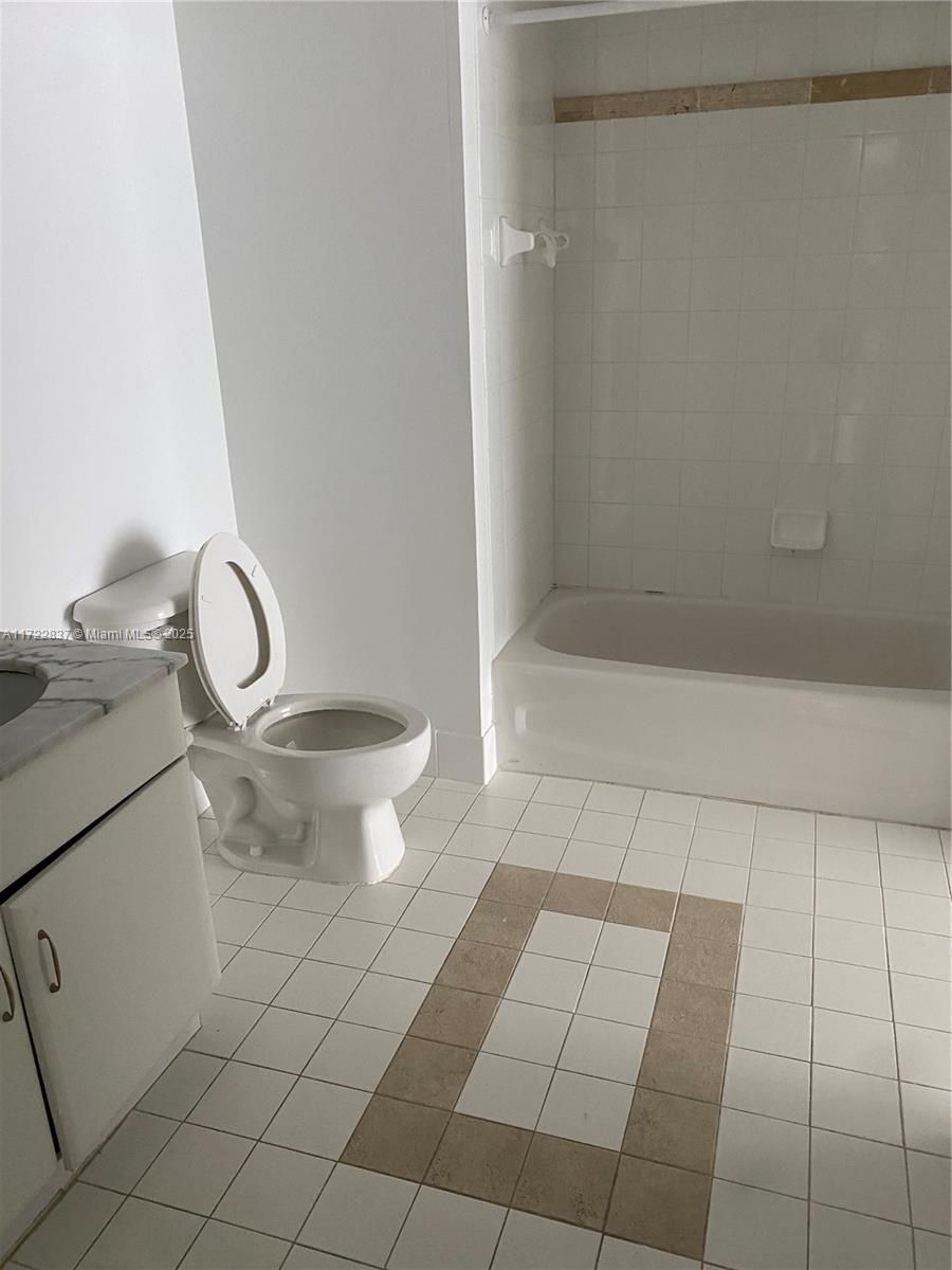 A bathroom features a white toilet, a vanity with a stone countertop, and a tiled tub — 1200 Brickell Bay Dr # 2007, Miami FL 33131, MIAMI, FL