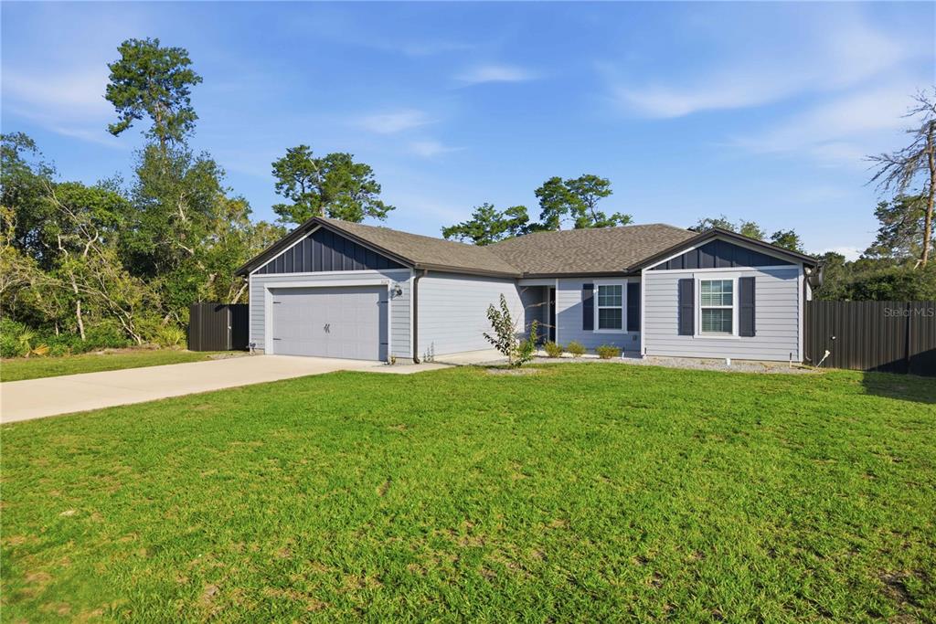 A single-story house with light gray siding, a two-car garage, and a large front lawn — 3125 SW 172ND LANE ROAD, OCALA, FL