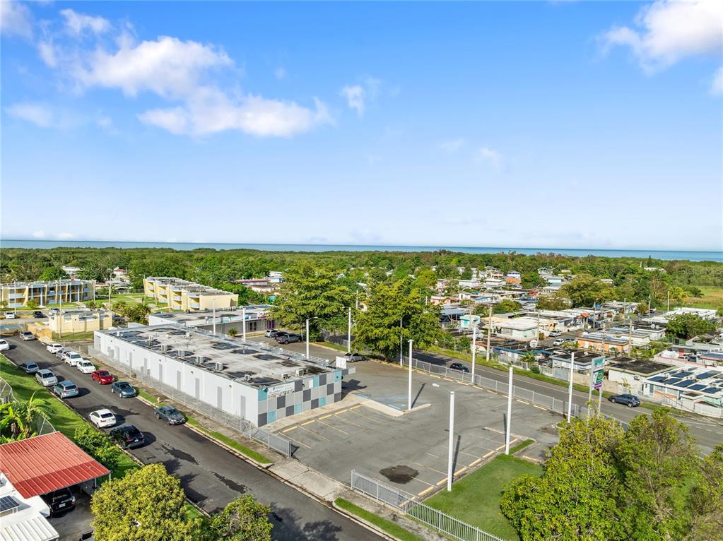 An aerial view shows a commercial building with a parking lot near a coastal area — 308 KM 5.3, CABO ROJO, PR