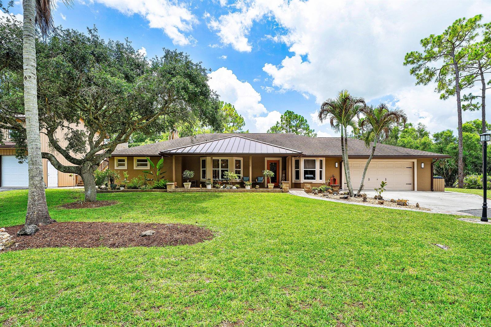 A single-story house with a brown exterior, metal roof, and a large front lawn — 14732 63rd Court N, Loxahatchee FL 33470, LOXAHATCHEE, FL