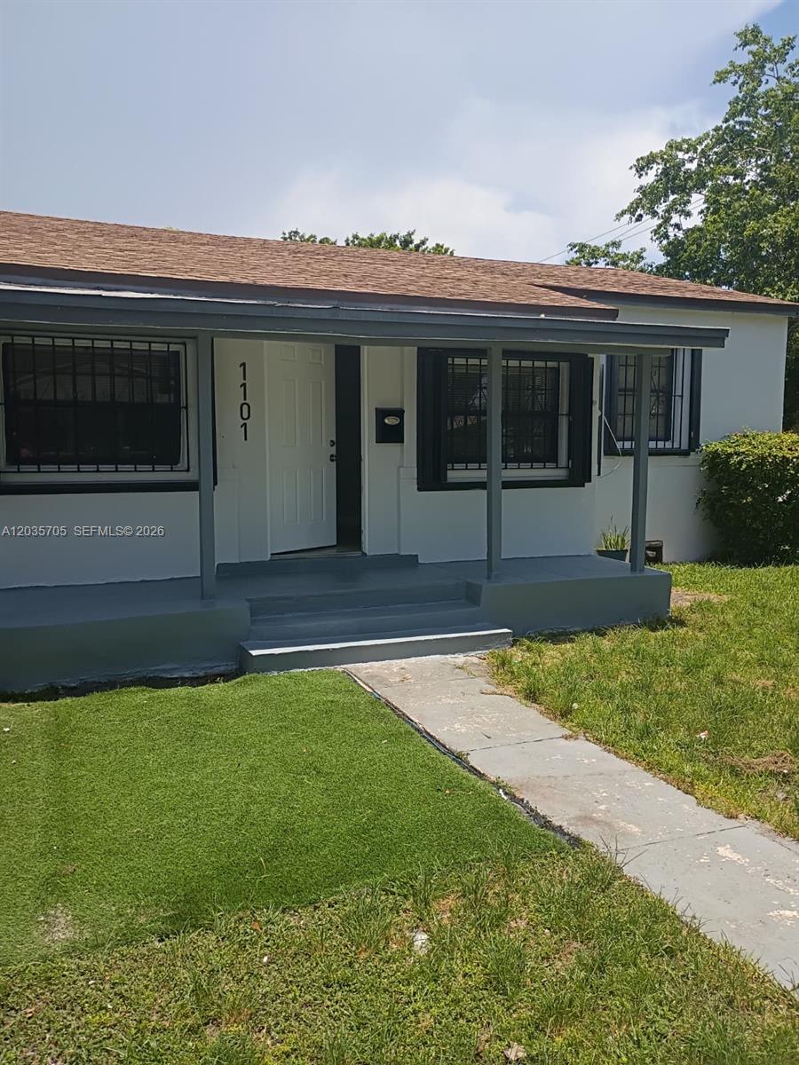 The exterior of a single-story house features a covered porch, white door, and security bars — 1101 NW 55th Ter, Miami FL 33127, MIAMI, FL