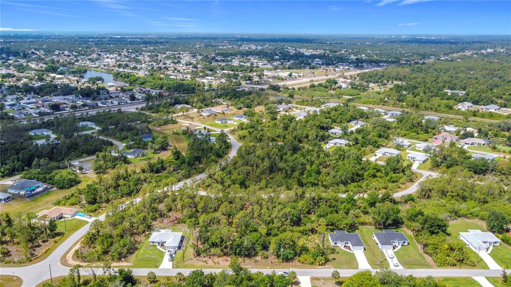 An aerial view shows a residential neighborhood with houses surrounded by dense trees and vegetation — LISA BOULEVARD, NORTH PORT, FL