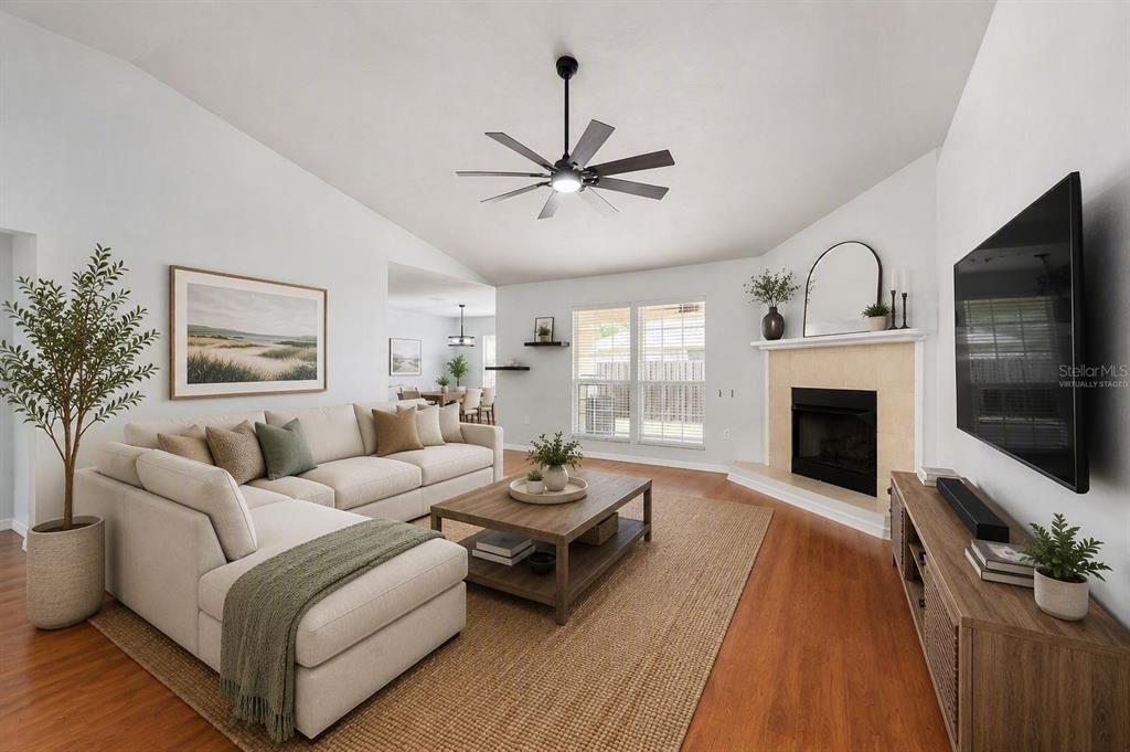 A living room with a sectional sofa, coffee table, fireplace, and hardwood floors — 25670 NW 9TH ROAD, NEWBERRY, FL