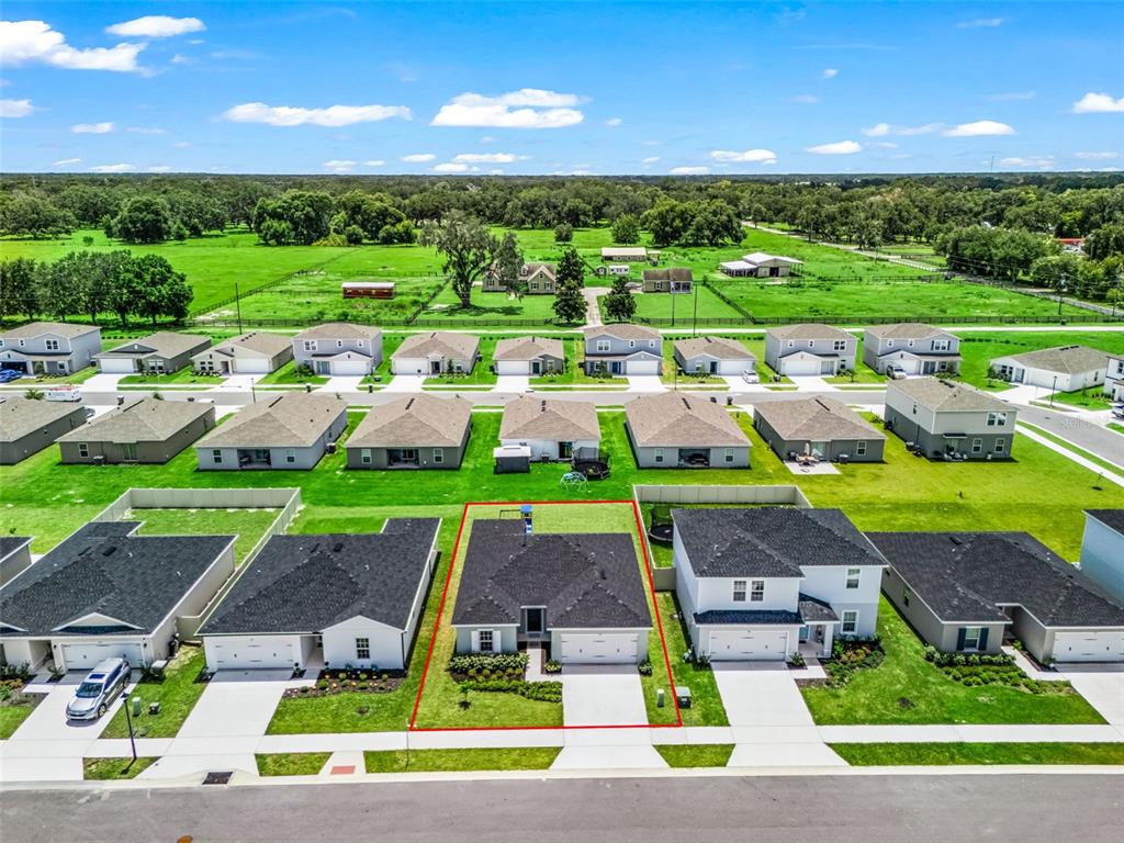 An aerial view shows a single-story house with a dark roof outlined in red — 1565 TEXAS AVENUE, SUMTERVILLE, FL