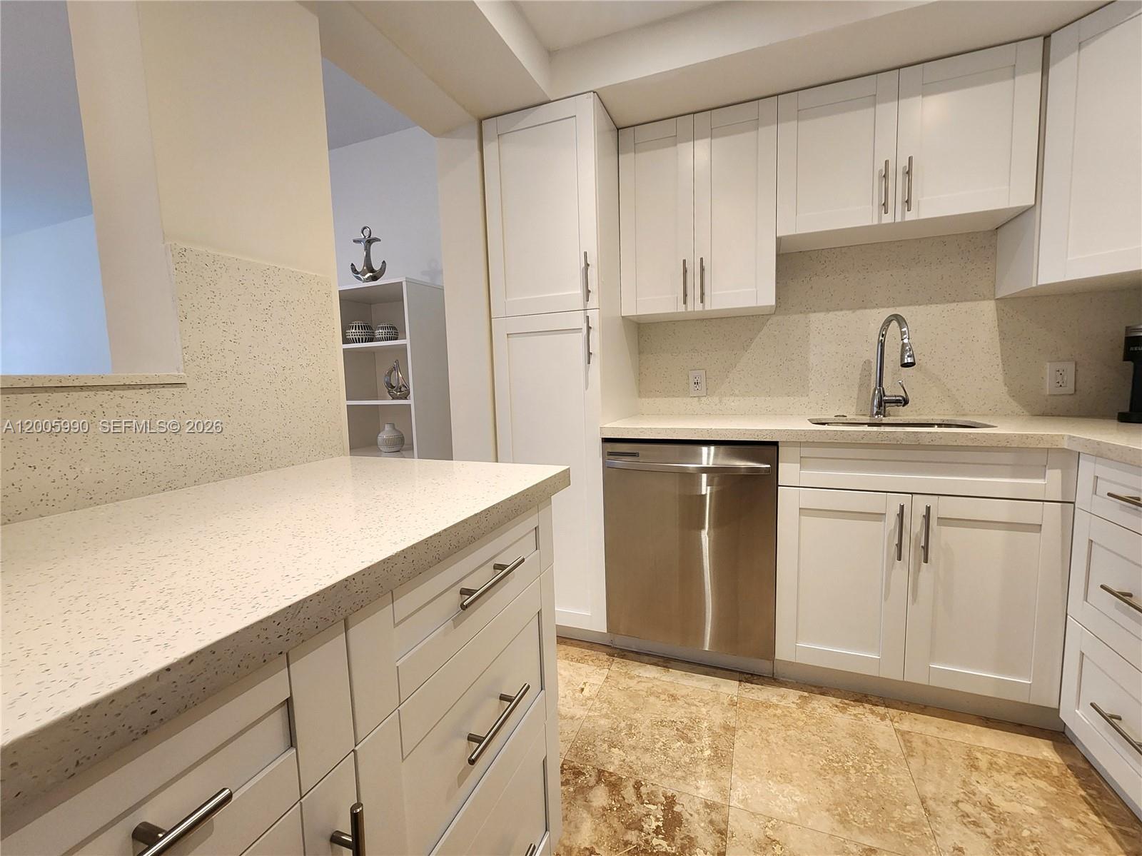 A kitchen features white cabinets, stainless steel appliances, and speckled countertops over tile flooring — 3505 S Ocean Dr # 209, Hollywood FL 33019, HOLLYWOOD, FL