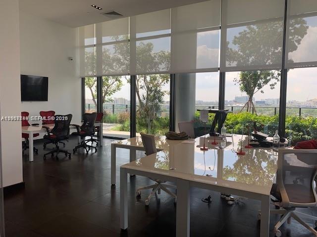 A modern office space features white desks, rolling chairs, and floor-to-ceiling windows with city views — 1600 NE 1st Ave # 3319, Miami FL 33132, MIAMI, FL