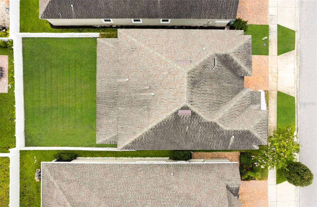 An aerial view shows the roof of a house, its backyard, and neighboring properties — 2408 CHATEAU LOOP, KISSIMMEE, FL