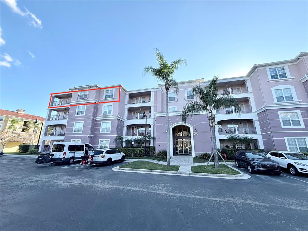 A multi-story apartment building exterior features a red-outlined top-floor unit with a balcony — 4840 CAYVIEW AVENUE UNIT 403, ORLANDO, FL