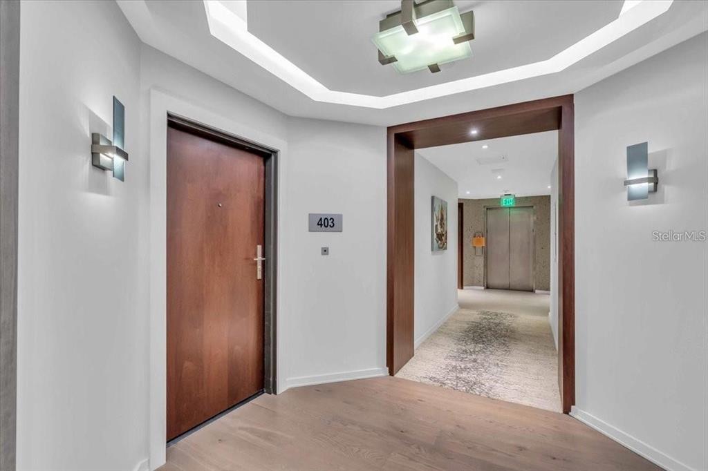 A hallway features a wooden door labeled 403, recessed lighting, and an elevator in view — 1211 GULF OF MEXICO DRIVE UNIT 403, LONGBOAT KEY, FL