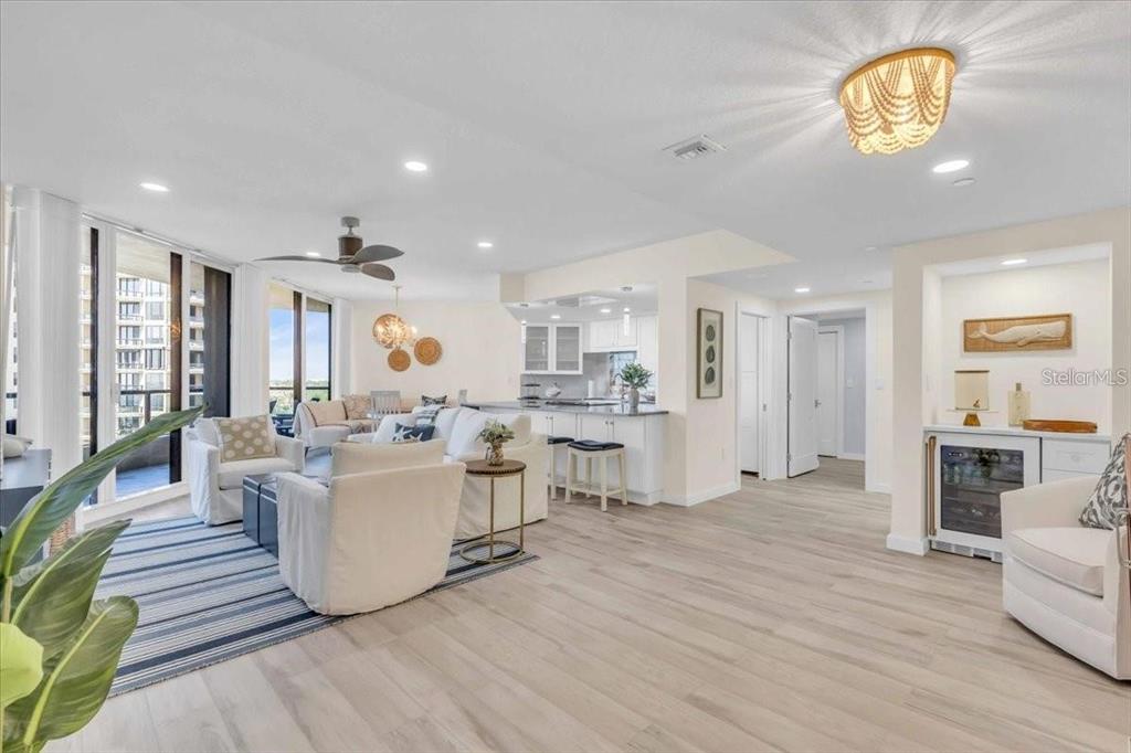 An open-concept living room and kitchen featuring light wood flooring and coastal-style decor — 1211 GULF OF MEXICO DRIVE UNIT 403, LONGBOAT KEY, FL