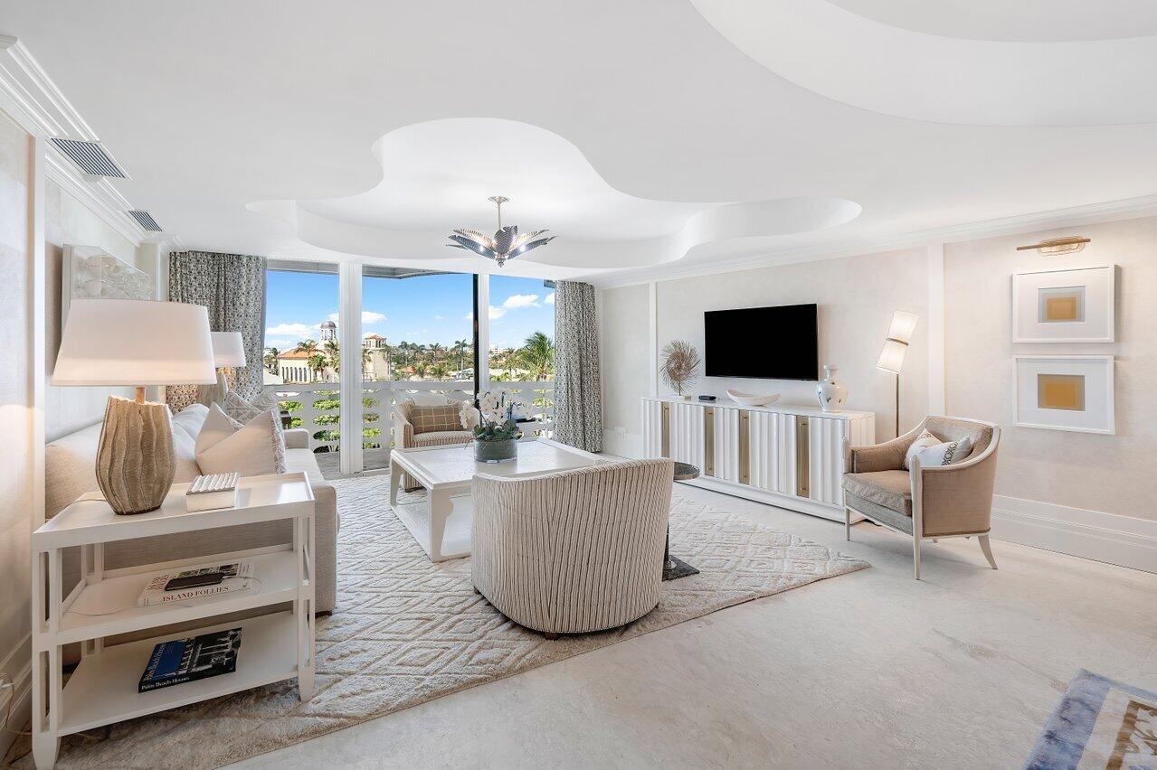 A bright living room features a unique tray ceiling, white furniture, and a balcony view — 130 Sunrise Avenue # 616, Palm Beach FL 33480, PALM BEACH, FL