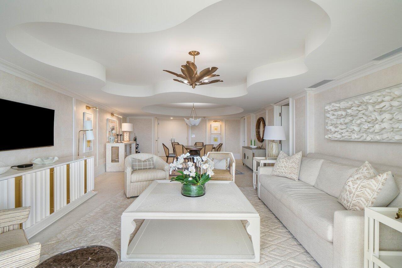 A bright living room features a coffered ceiling, neutral furniture, and a large coffee table — 130 Sunrise Avenue # 616, Palm Beach FL 33480, PALM BEACH, FL