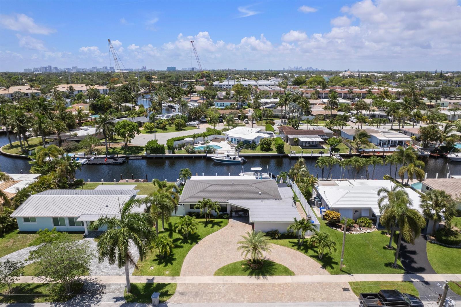 An aerial view of a waterfront house with a paved driveway, palm trees, and canal — 160 SE 12th Court, Pompano Beach FL 33060, POMPANO BEACH, FL