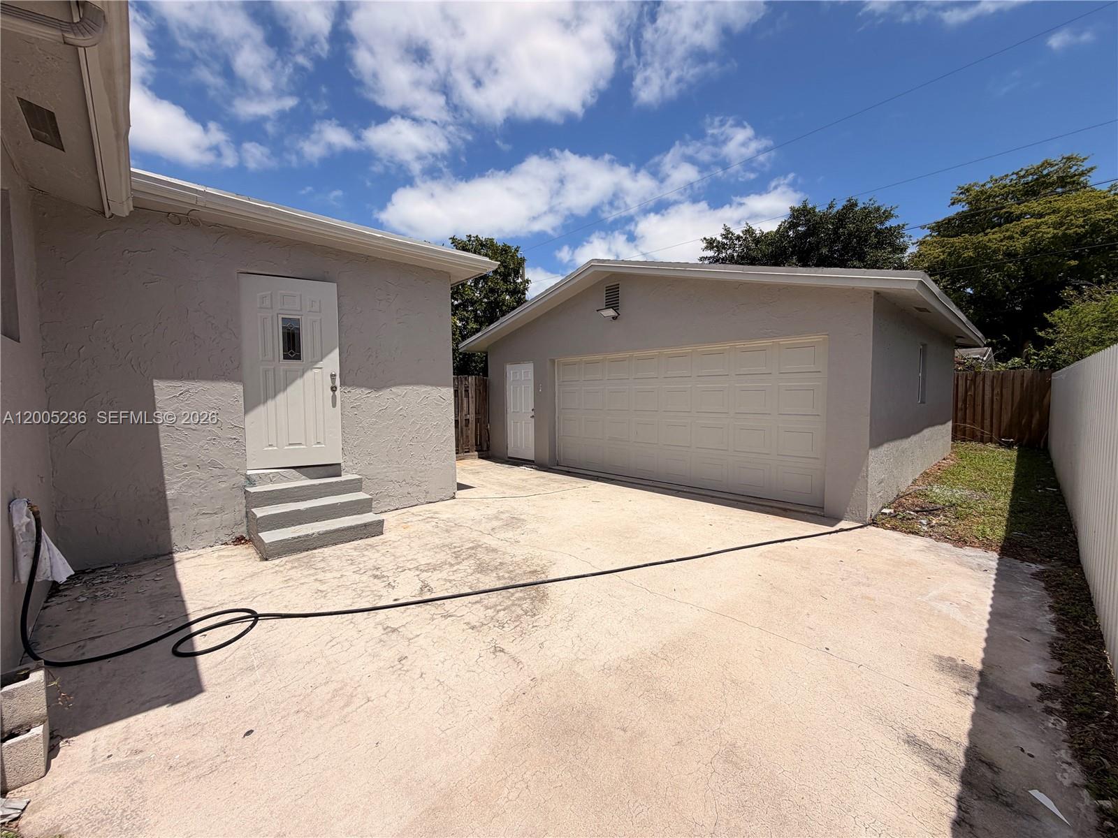 A concrete driveway leads to a detached garage and a house entrance with steps — 3011 N 74th Ave # B, Hollywood FL 33024, HOLLYWOOD, FL