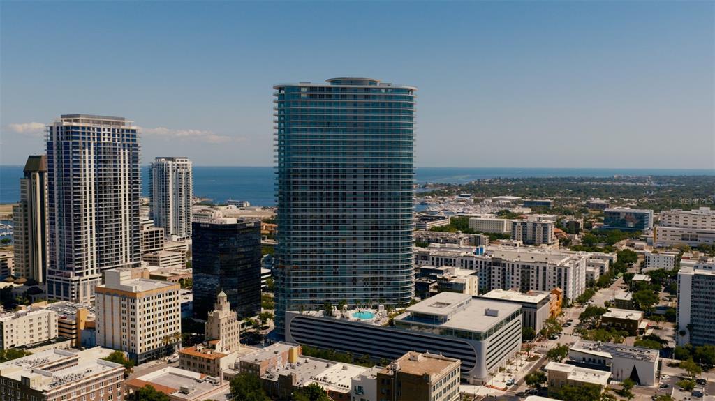 An aerial view of a city skyline featuring a prominent glass skyscraper and surrounding buildings — 400 CENTRAL AVENUE UNIT 3107, ST PETERSBURG, FL