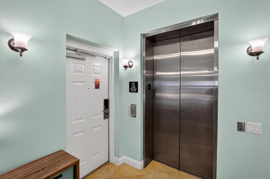 An elevator and a white door are set against light green walls in a hallway — 200 OCEAN CREST DRIVE UNIT 646, PALM COAST, FL