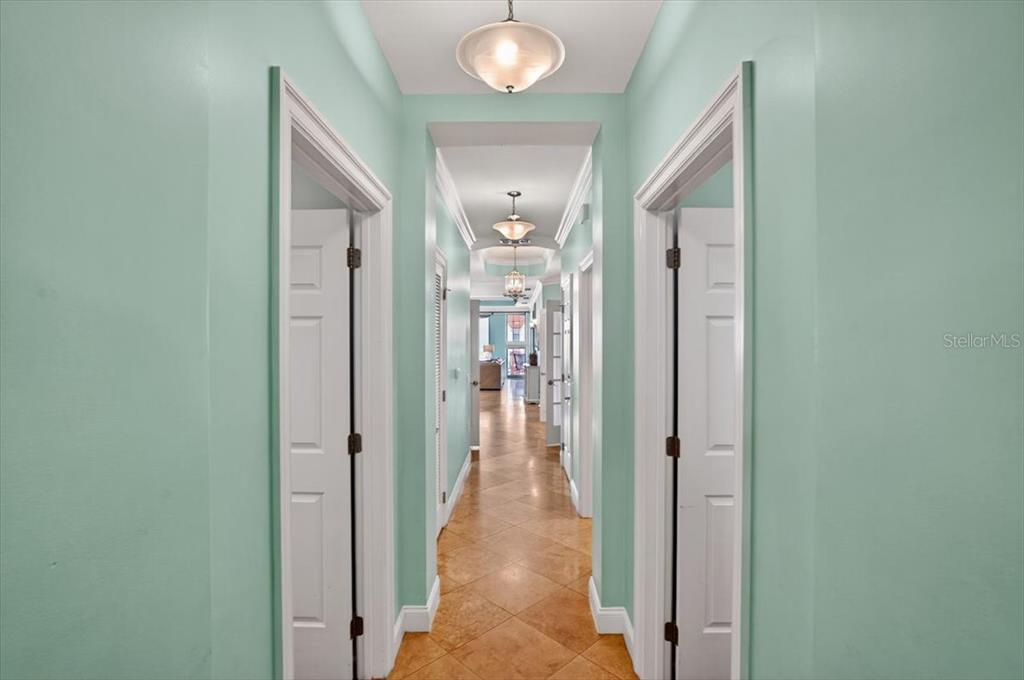 A hallway with light green walls, tile flooring, and multiple white doors leads forward — 200 OCEAN CREST DRIVE UNIT 646, PALM COAST, FL