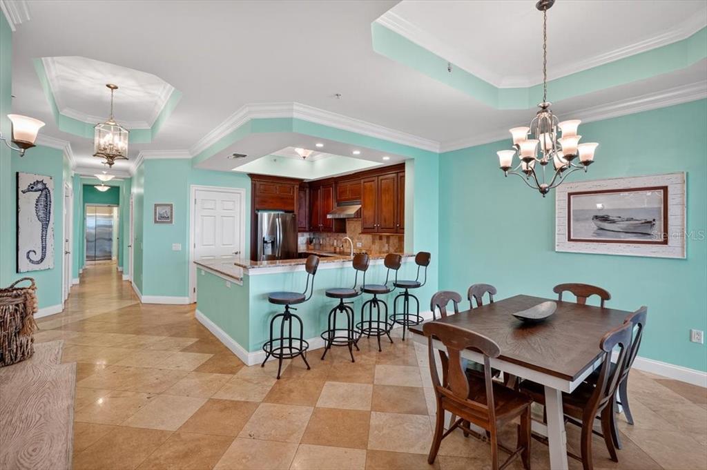 A dining area and kitchen with light blue walls, tile floors, and dark wood cabinetry — 200 OCEAN CREST DRIVE UNIT 646, PALM COAST, FL