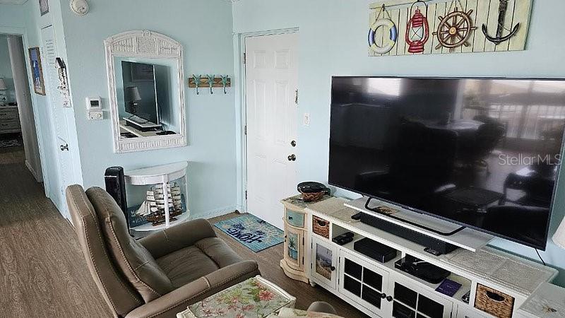 A living room features a large television, a recliner, and nautical-themed wall decor — 1255 TARPON CENTER DRIVE UNIT 304, VENICE, FL