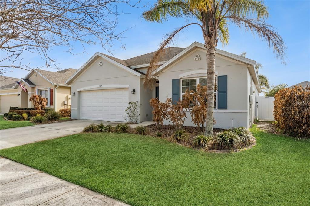 A single-story suburban house with a two-car garage, palm tree, and front lawn — 5617 YEARLING DRIVE, TITUSVILLE, FL