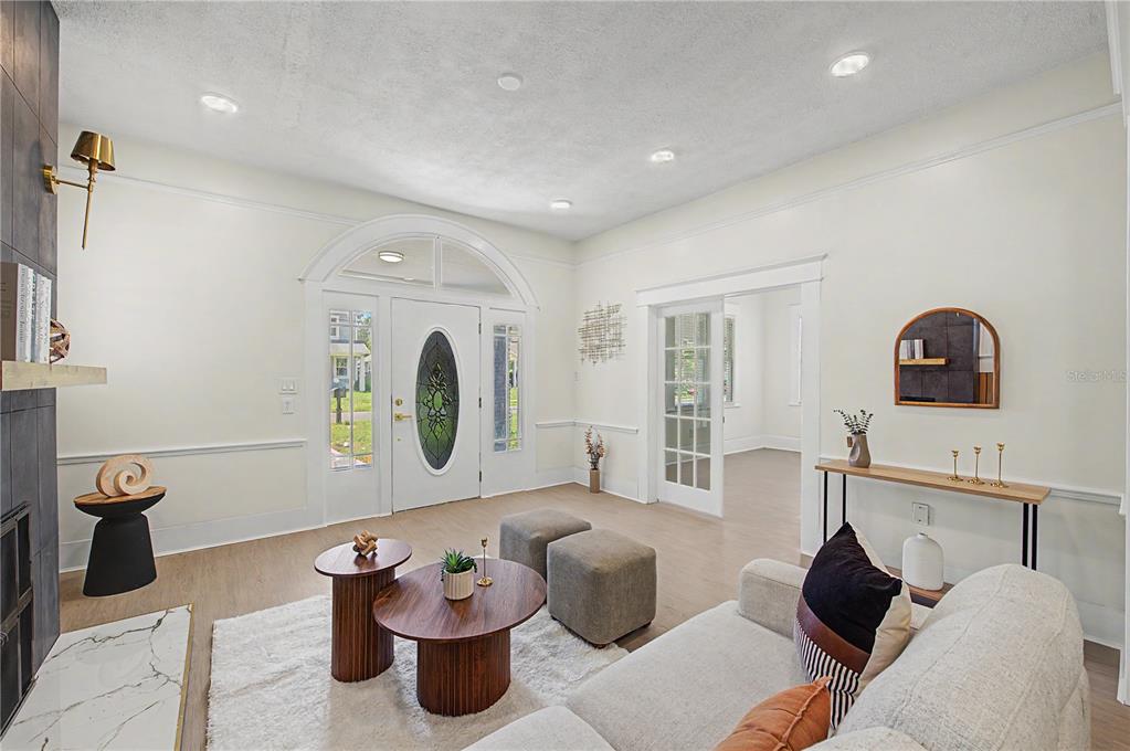 A living room features a fireplace, white walls, a front door, and a sofa — 1920 E PARIS STREET, TAMPA, FL