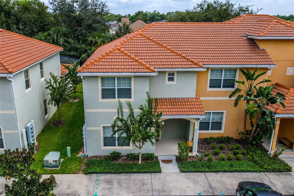 An exterior view of a two-story townhouse with a tiled roof and a small entryway — 2963 BANANA PALM DRIVE, KISSIMMEE, FL