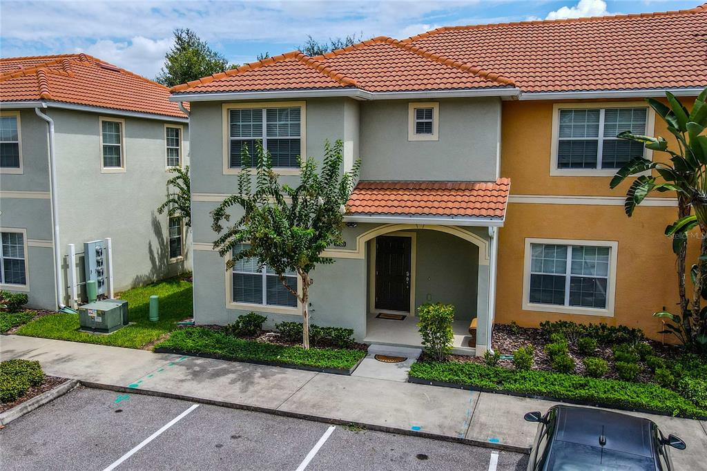 An exterior view of a two-story townhouse with a tiled roof and a covered entryway — 2963 BANANA PALM DRIVE, KISSIMMEE, FL
