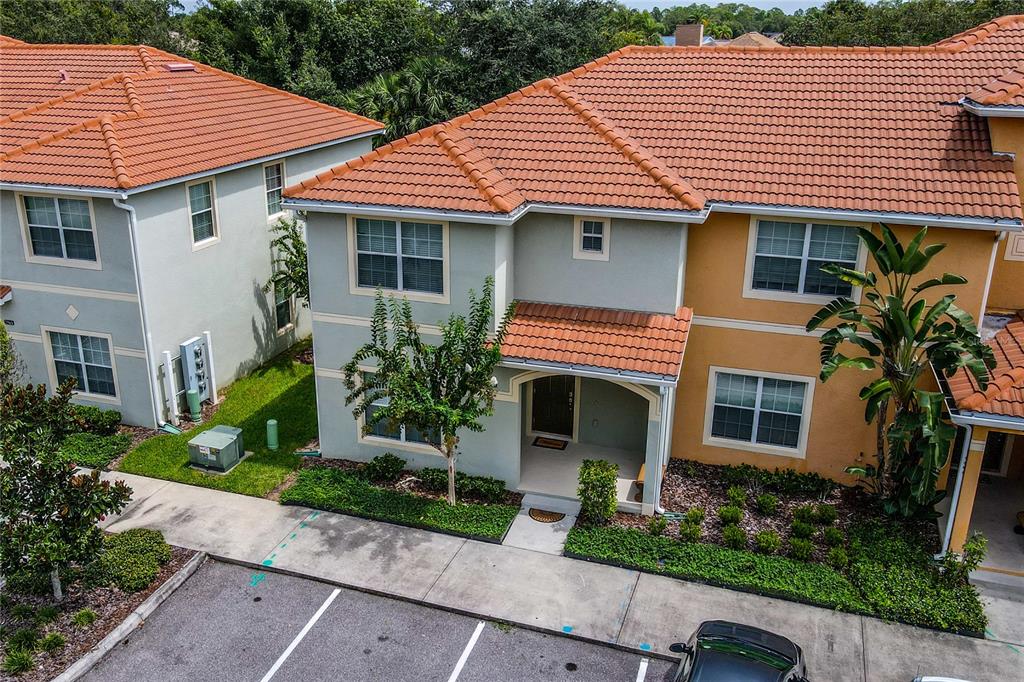 An exterior view of two-story townhomes with orange tile roofs and light-colored stucco walls — 2963 BANANA PALM DRIVE, KISSIMMEE, FL