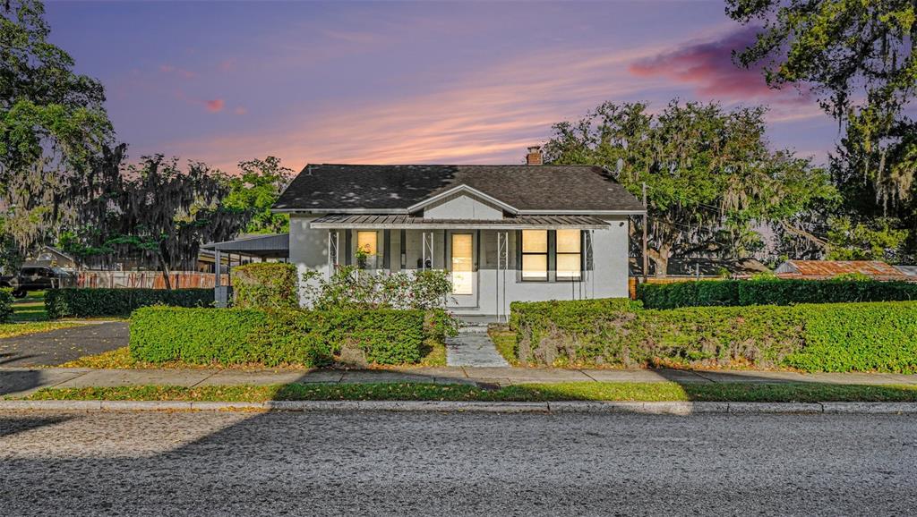 A single-story house with a gabled roof and a front porch sits behind a hedge — 514 SW 2ND AVENUE, OCALA, FL