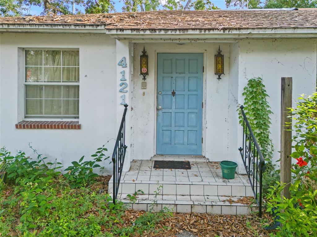 A light blue front door with a tiled porch and black metal railings — 4121 WEST PALMIRA AVENUE, TAMPA, FL