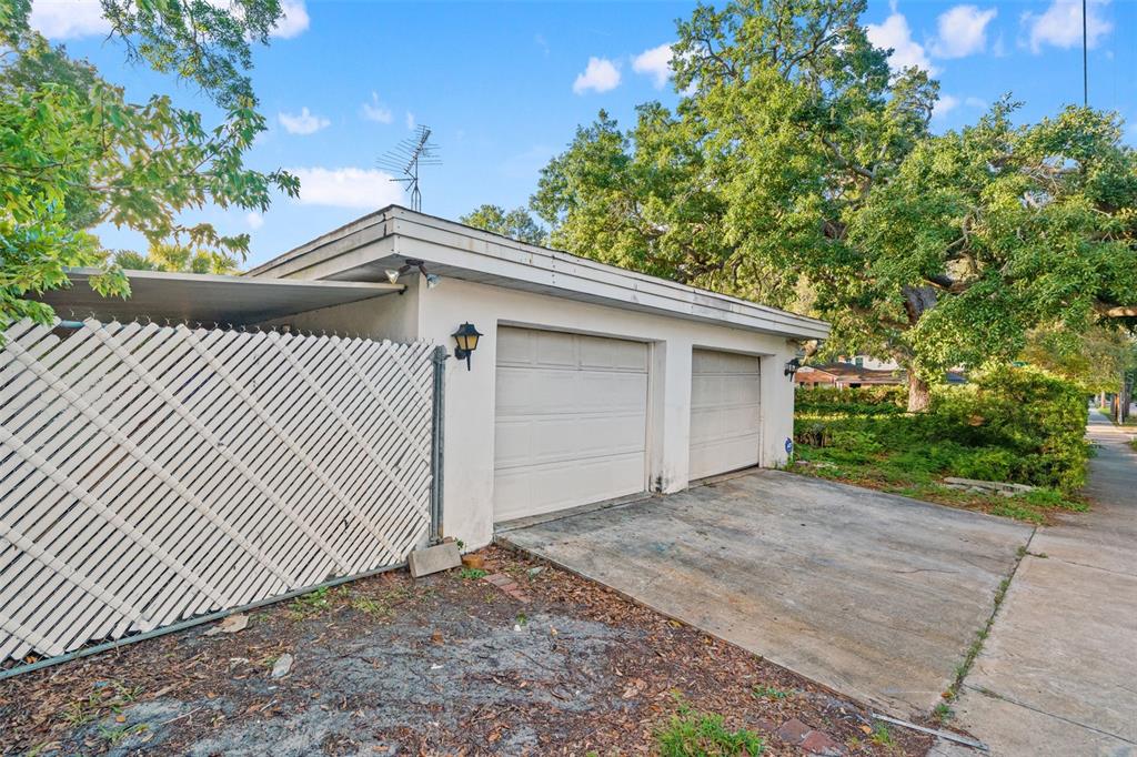 A detached two-car garage with a white lattice fence and a concrete driveway — 4121 WEST PALMIRA AVENUE, TAMPA, FL