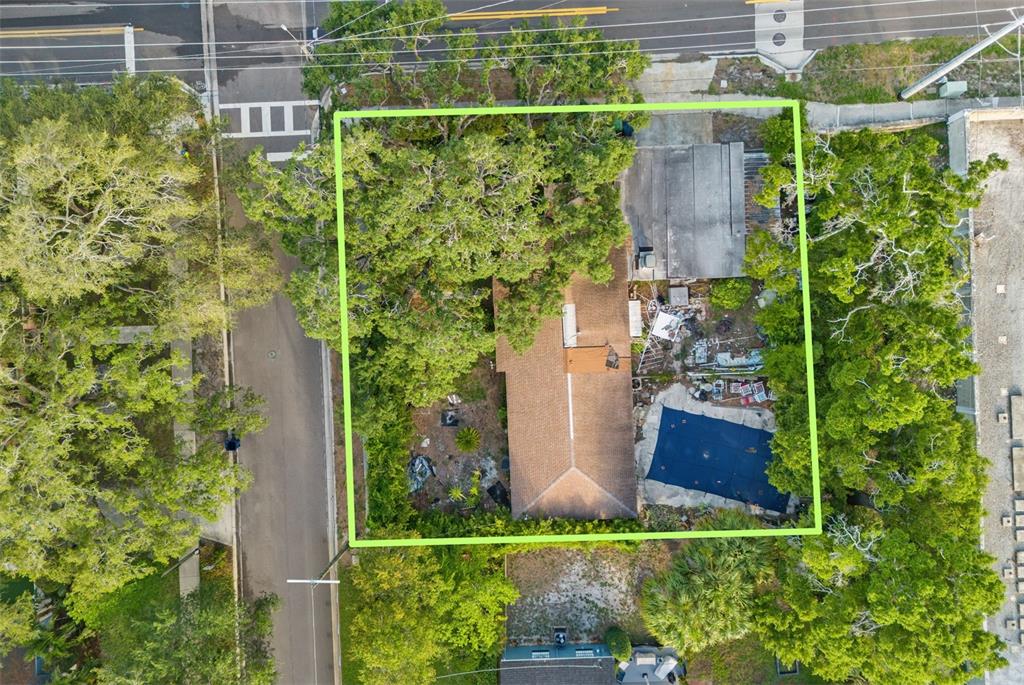 Aerial view of a residential property featuring a house, a pool, and mature trees — 4121 WEST PALMIRA AVENUE, TAMPA, FL