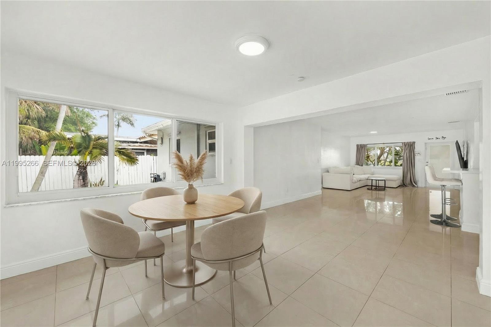 A dining area with a round table and chairs opens into a living room — 1435 Johnson St, Hollywood FL 33020, HOLLYWOOD, FL