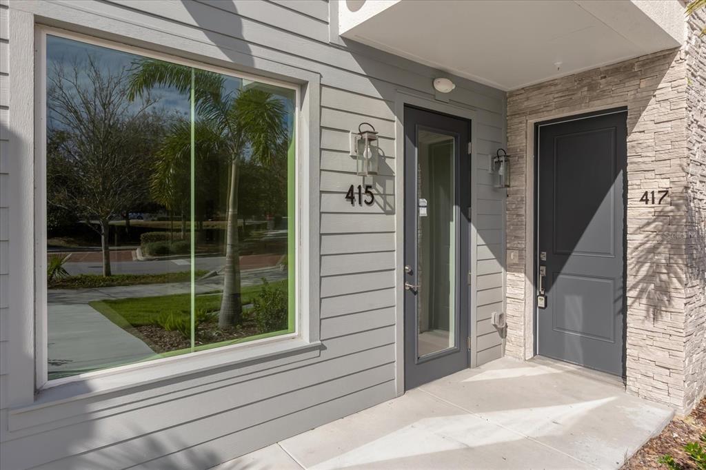 The exterior entrance features two gray doors with house numbers 415 and 417 — 415 MIKE ROBERTO WAY, OVIEDO, FL