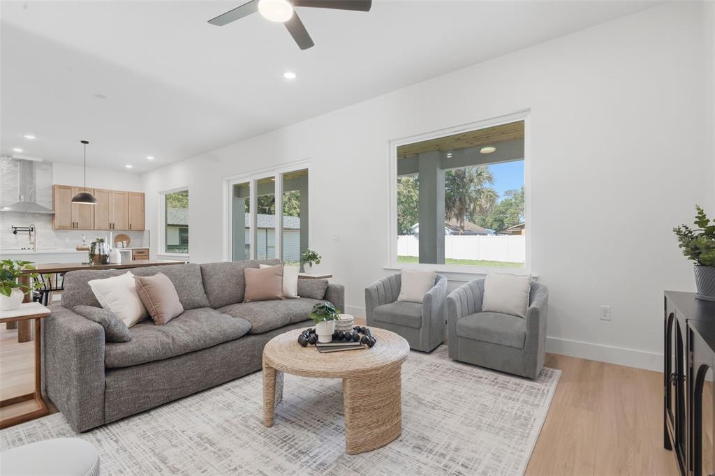 A living room features a grey sofa, two armchairs, a round table, and light wood floors — 1907 MAE STREET, ORLANDO, FL