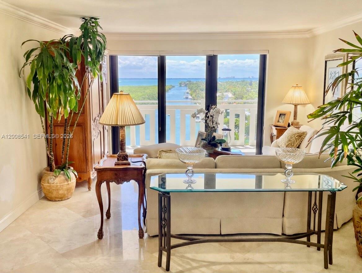 A living room features a beige sofa, glass console table, and a balcony with water views — 1121 Crandon Blvd # D903, Key Biscayne FL 33149, KEY BISCAYNE, FL