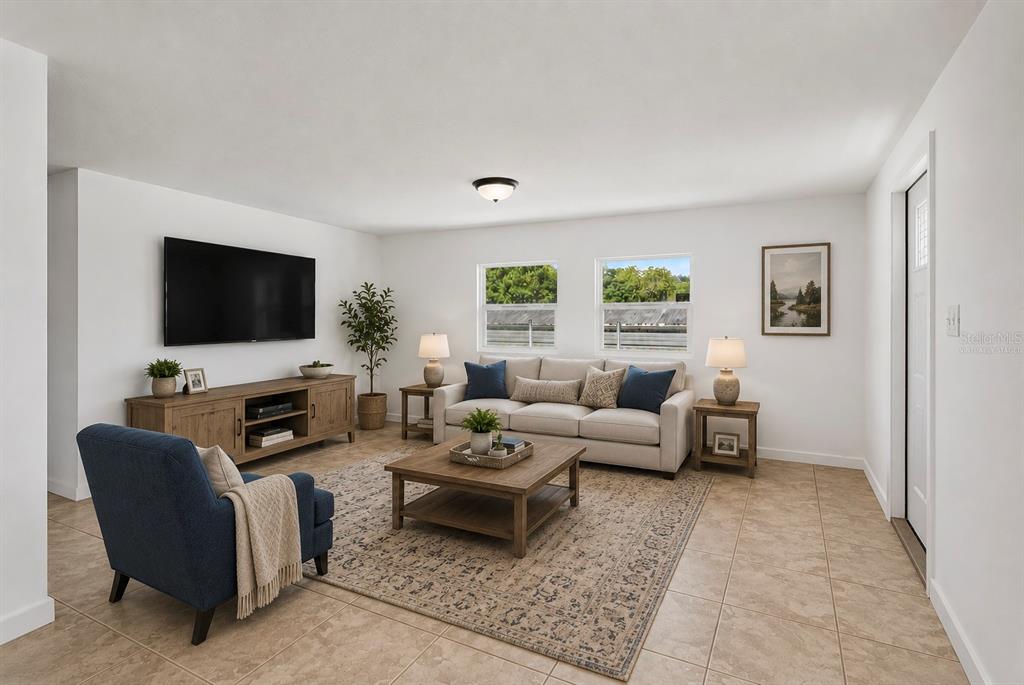 A living room features a beige sofa, blue armchair, wooden coffee table, and tile flooring — 17230 ADAM COURT, MONTVERDE, FL