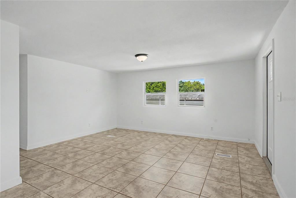 An empty room features white walls, tile flooring, two windows, and a ceiling light fixture — 17230 ADAM COURT, MONTVERDE, FL