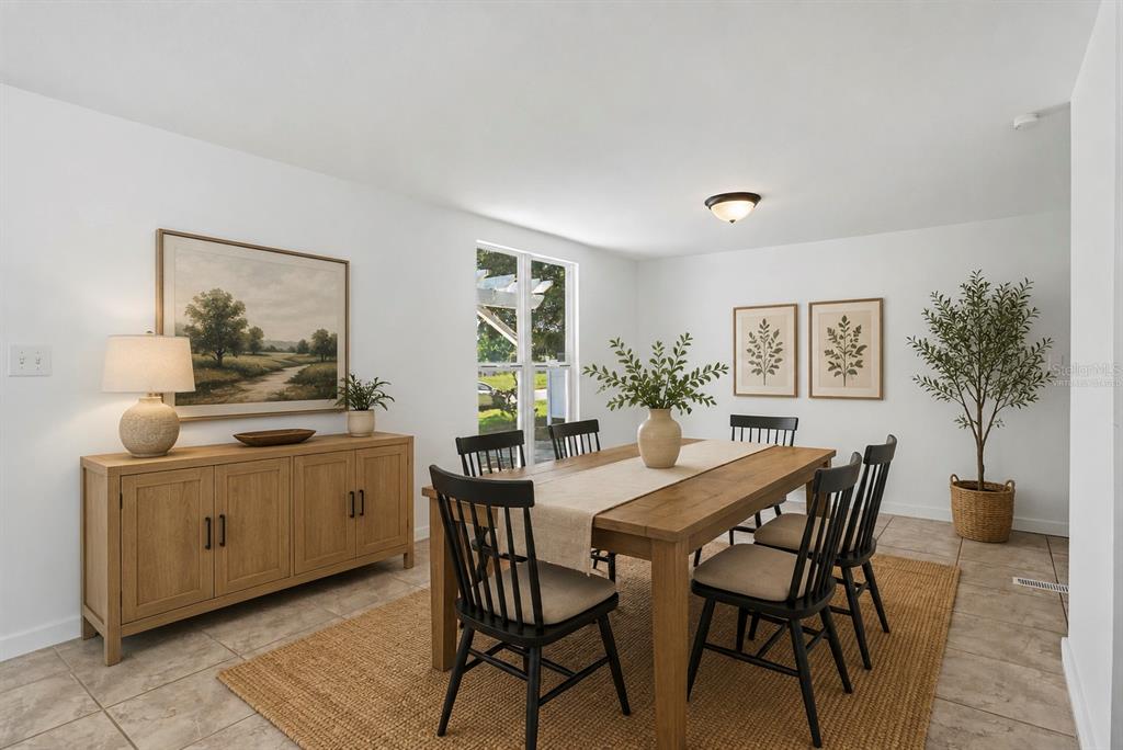A dining room features a wooden table with black chairs, a sideboard, and tile flooring — 17230 ADAM COURT, MONTVERDE, FL