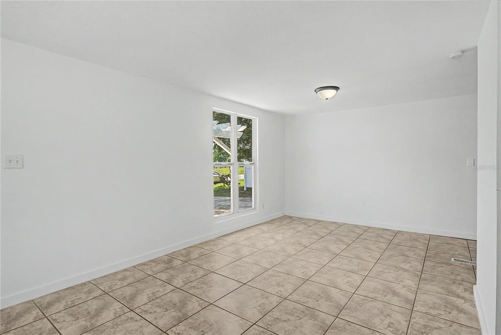 An empty room with white walls, tile flooring, a window, and a ceiling light fixture — 17230 ADAM COURT, MONTVERDE, FL