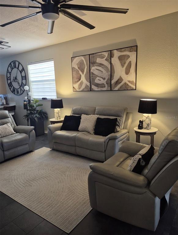 A living room features grey leather furniture, a patterned area rug, and abstract wall art — 6102 LAKE MARION GOLF RESORT, KISSIMMEE, FL