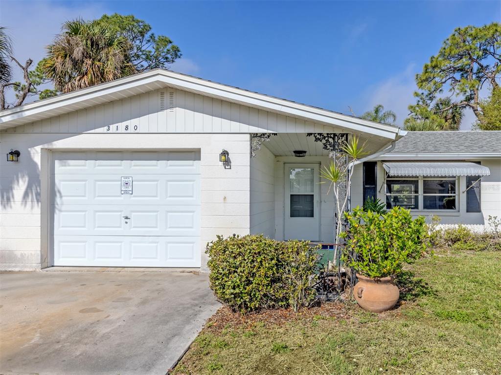 A single-story house with a white garage door, a front entrance, and a landscaped yard — 3180 FALLOW ROAD, VENICE, FL