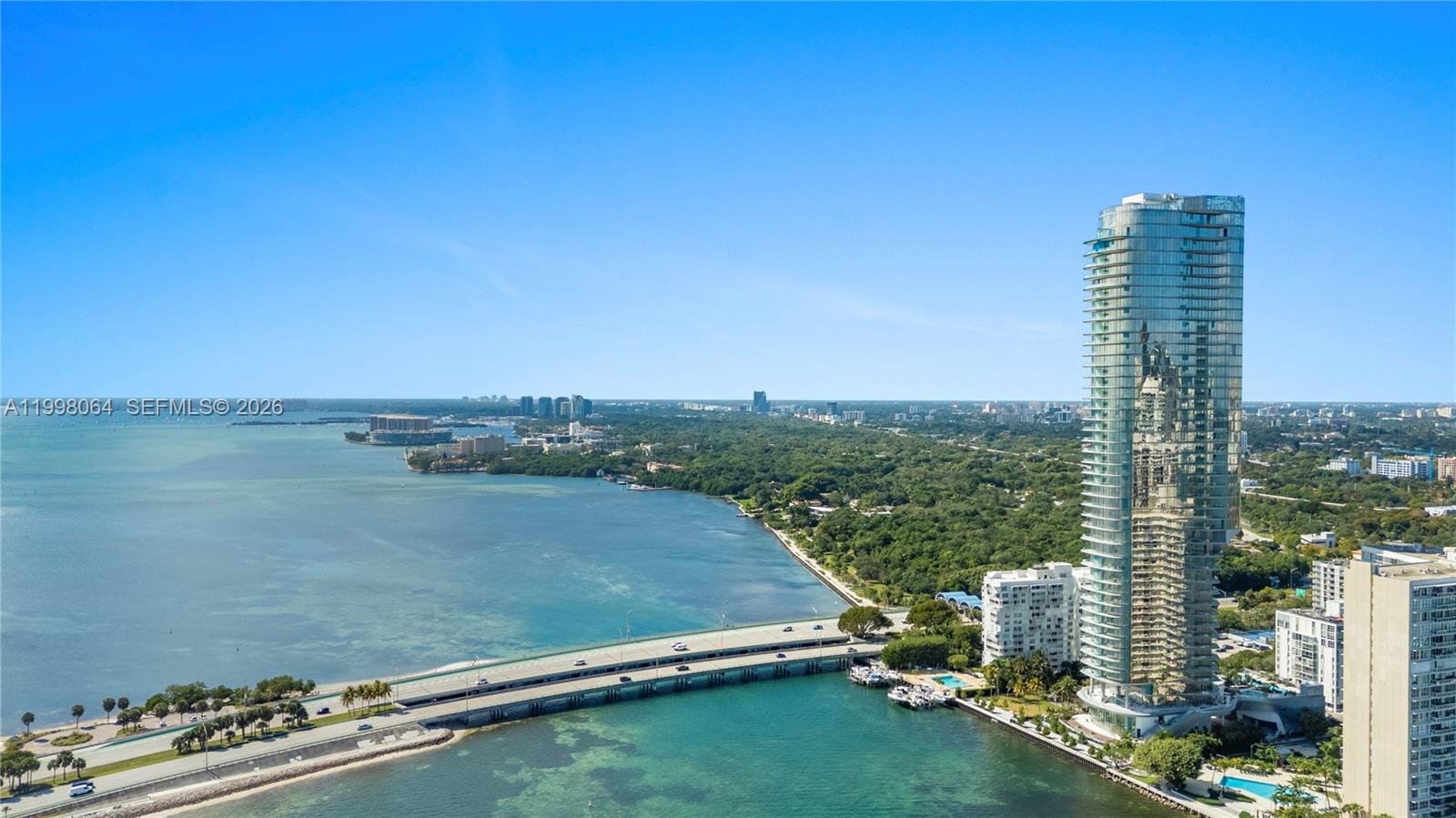 An aerial view shows a tall glass skyscraper next to a bridge over water — 175 SE 25 Rd # 2003, Miami FL 33129, MIAMI, FL